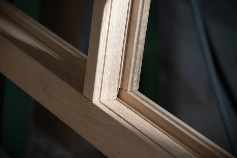 Detail eines Holzfensters mit fein gearbeitetem Rahmen