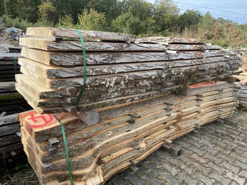 Gelagerte Silberahornbohlen mit Waldkante