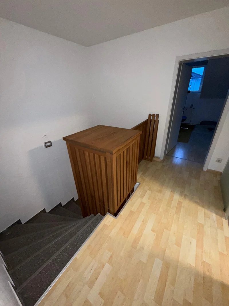 Blick vom oberen Geschoss auf die Eichenverkleidung und die abwärtsführende Treppe