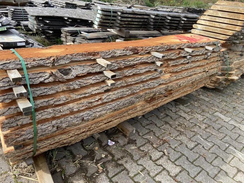 Aufgestapelte Zedernbohlen mit natürlicher Waldkante